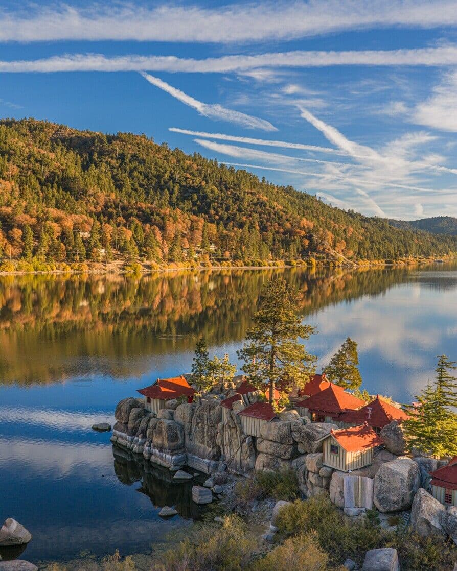 Red-roofed cabins on the boulders of the lakeshore in fall