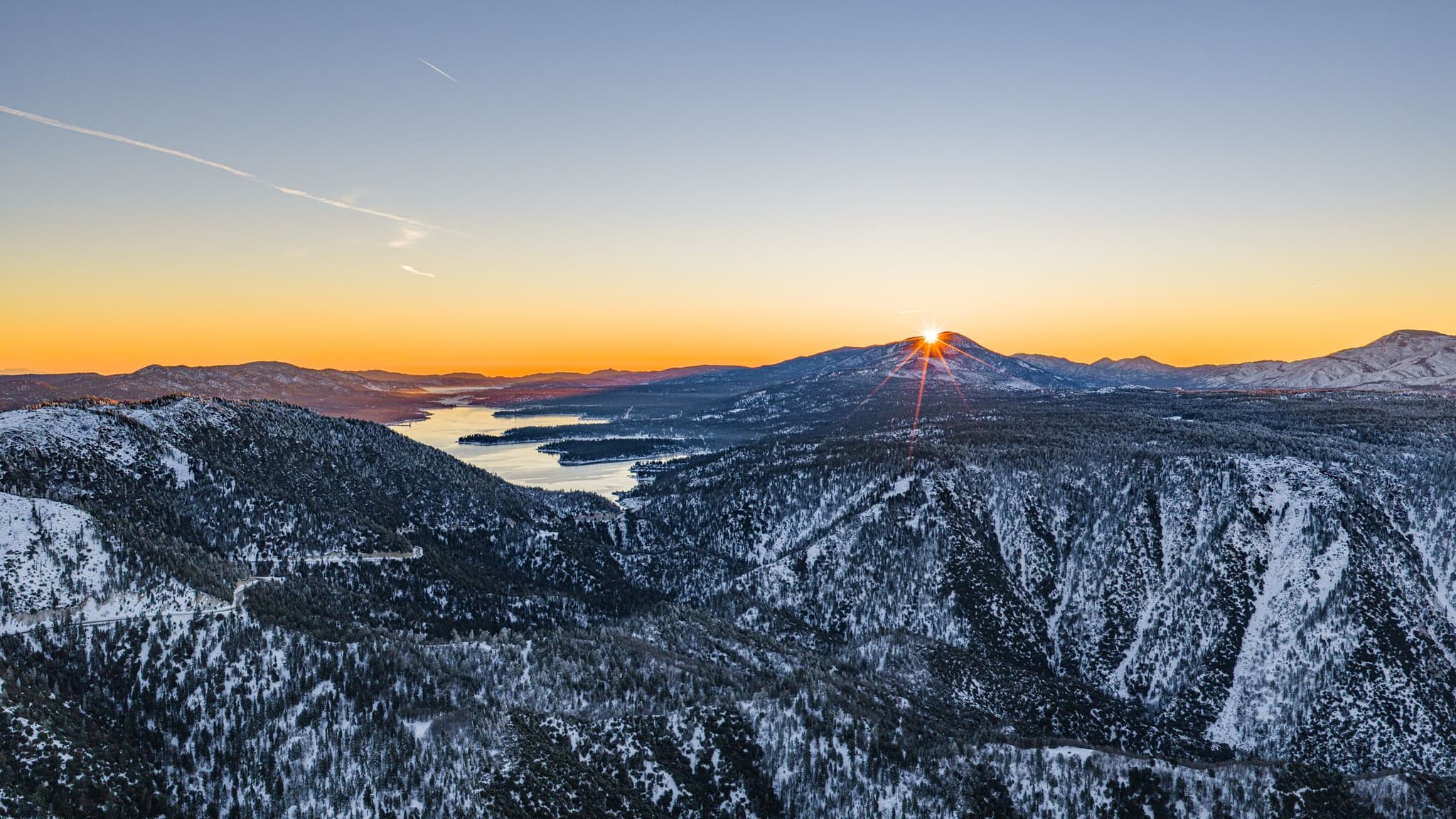 Sunrise over snow-covered mountains and the lake